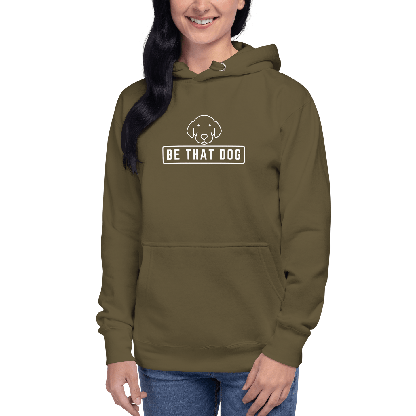 A person is wearing the THiNK LiKE A DOG® "Be THAT Dog Minimalist Hoodie," an ultra-soft olive green sweatshirt featuring a sleek dog design and the text "BE THAT DOG." It's a cozy essential for any dog lover.