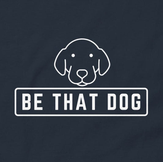 Showcase your dog-lover style with the Be THAT Dog Minimalist Pup Face Tee by THiNK LiKE A DOG®, featuring a line drawing of a dog's face above the bold text "BE THAT DOG" on a dark background.