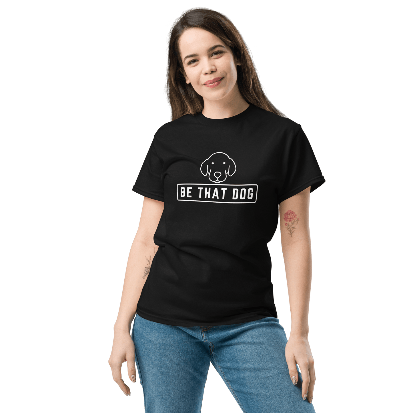 A dog lover dons the Be THAT Dog Minimalist Pup Face Tee by THiNK LiKE A DOG®, a comfortable cotton, black T-shirt with "Be That Dog" text and minimalist design, perfectly paired with blue jeans.
