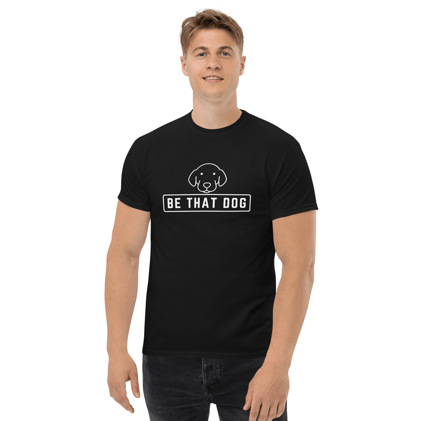 A man stands smiling in a THiNK LiKE A DOG® Be THAT Dog Minimalist Pup Face Tee, a comfortable black cotton t-shirt featuring a minimalist dog design and the text "BE THAT DOG.