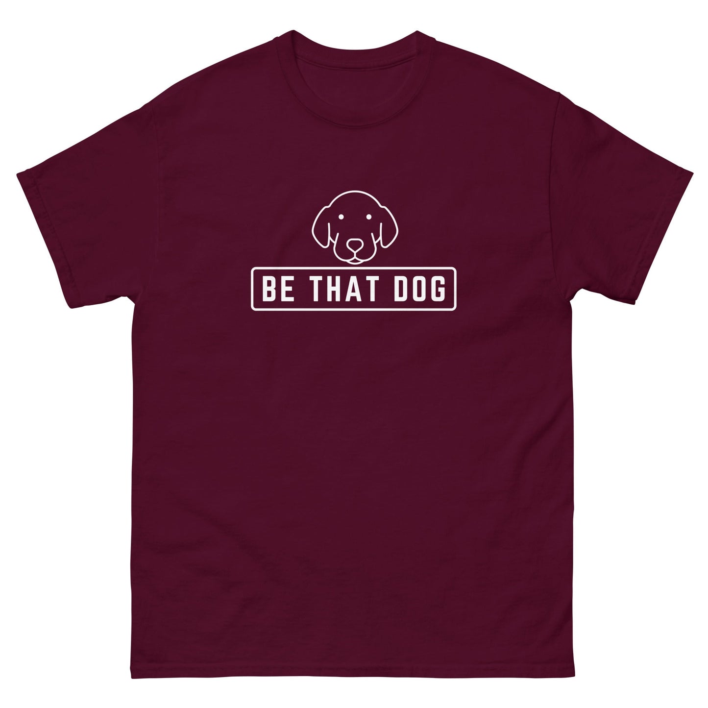 The "Be THAT Dog Minimalist Pup Face Tee" by THiNK LiKE A DOG® is a maroon t-shirt made of 100% cotton, featuring a minimalist dog design above the bold "BE THAT DOG" text in white, ideal for any dog lover.