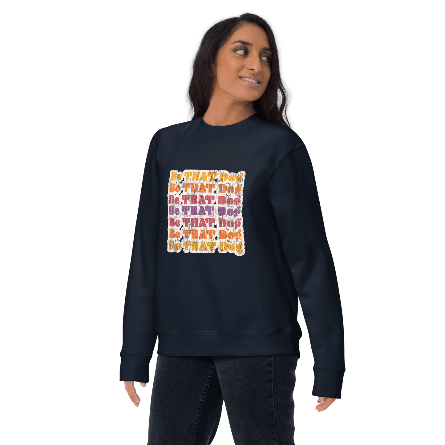 Clad in THiNK LiKE A DOG®'s Be THAT Dog Retro Sweatshirt, featuring a colorful '70s-style text pattern, the person looks back over their shoulder. This unisex sweater is a vintage-inspired essential for any dog lover's casual outing.