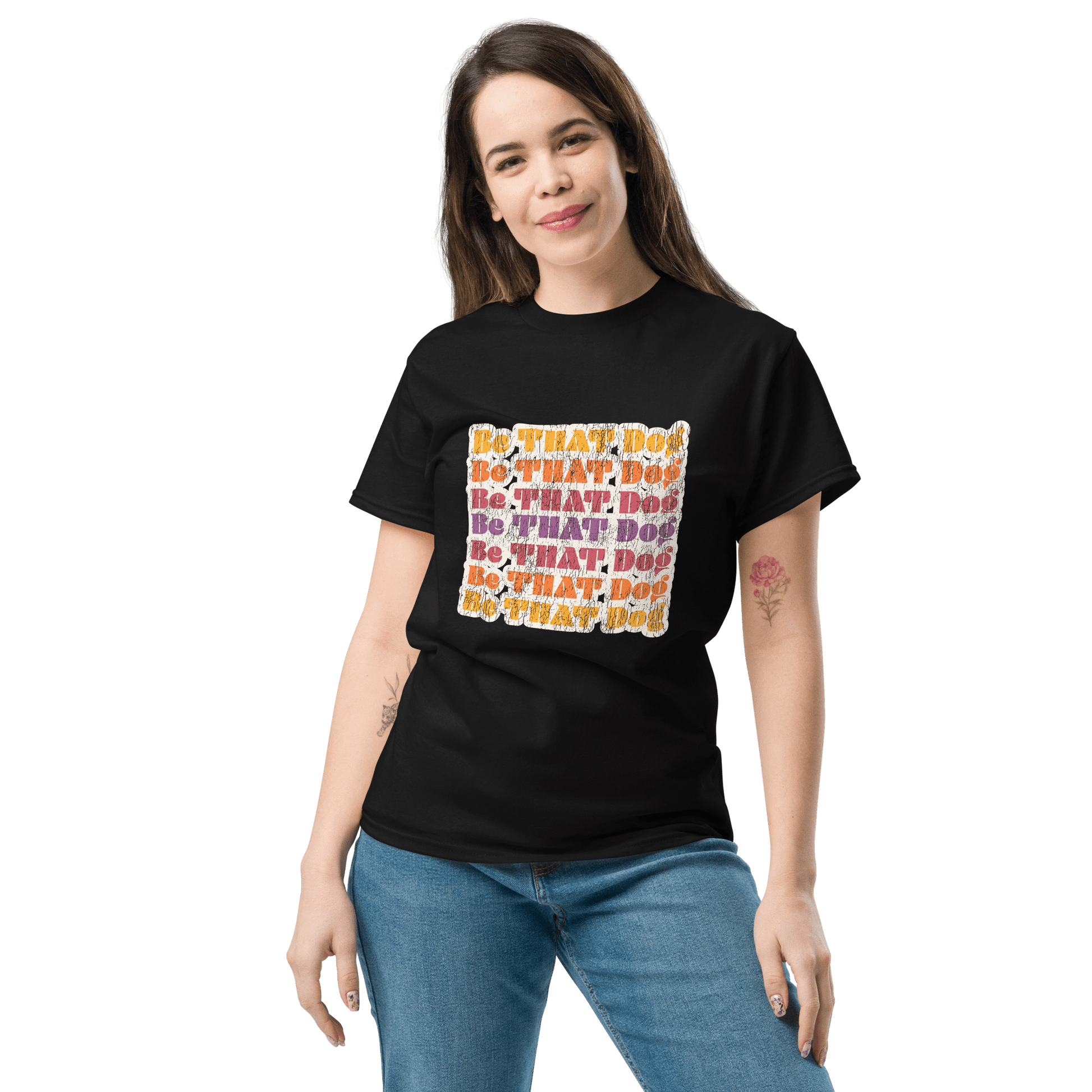 A person stands with hands by their side, wearing the Be That Dog Retro Unisex Tee by THiNK LiKE A DOG®. This '70s-inspired black shirt features "DO THAT DOG" in colorful letters and captures a playful spirit, perfect for dog lovers.