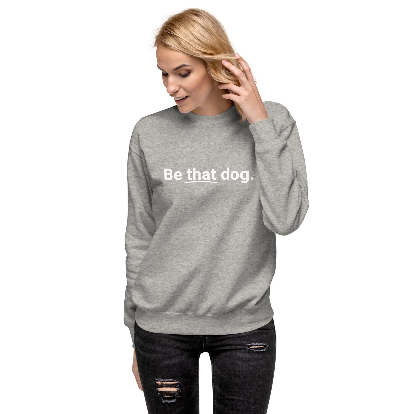A woman wears the THiNK LiKE A DOG® "Be That Dog Sweatshirt – Simple Statement," a cozy unisex crewneck with "Be that dog." in white, styled with black jeans—the perfect dog lovers' gift, pictured against a white background.