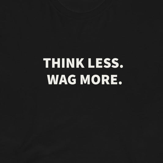 The Think Less. Wag More. Dog Lover Tee by THiNK LiKE A DOG® features white text on a black shirt—perfect for any dog lover’s collection or proud dog parent!.