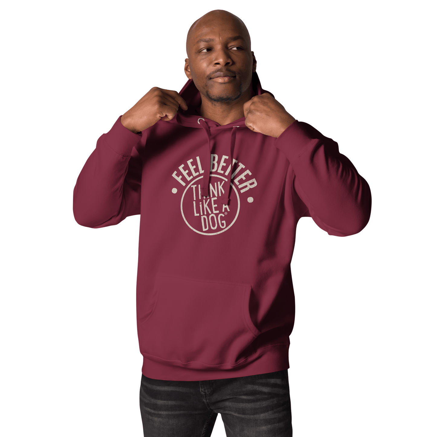 A man sports a maroon Feel Better Dog Lover Hoodie from THiNK LiKE A DOG®, emblazoned with "Feel Better, THiNK LiKE A DOG." He adjusts his hood, gazing thoughtfully to the side.