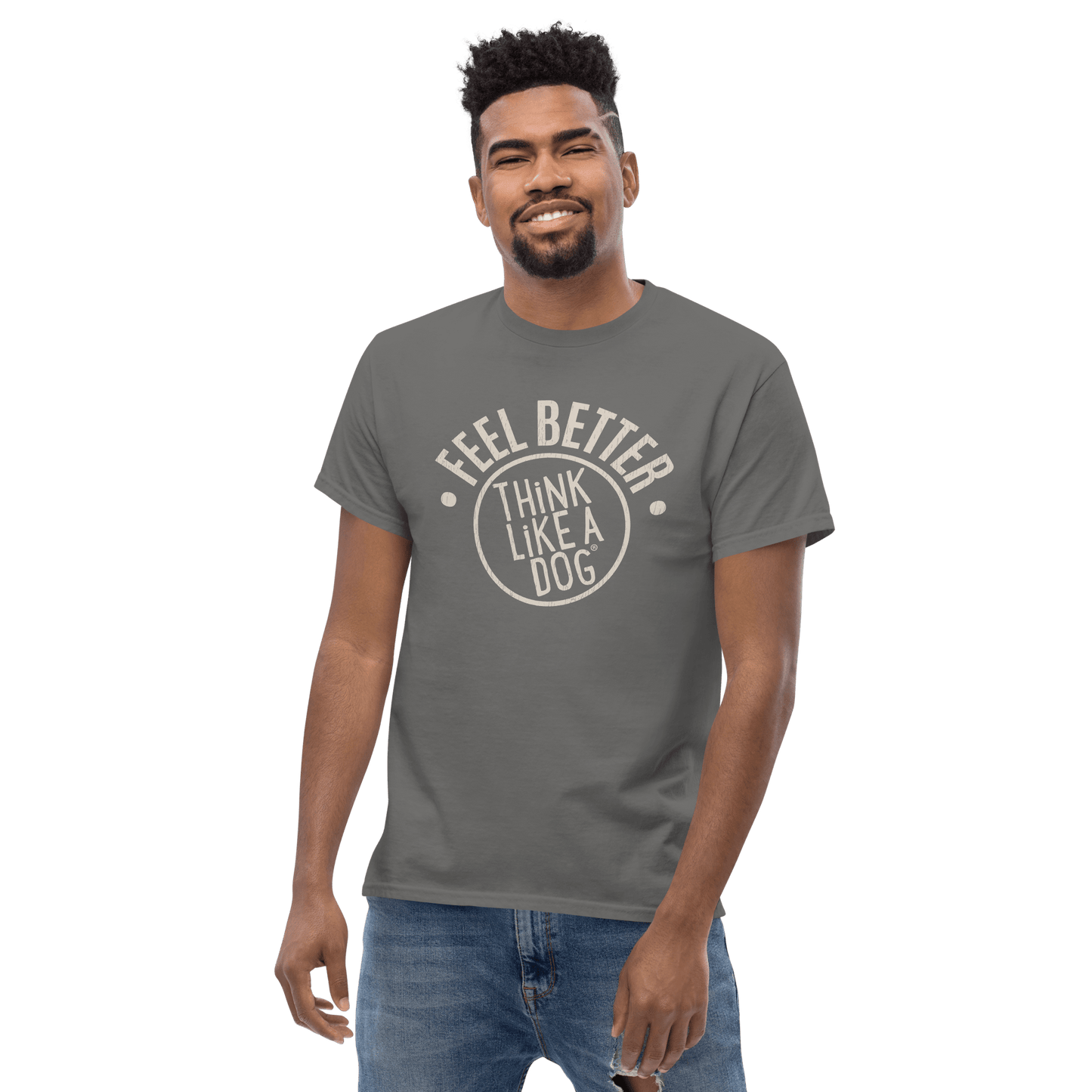 A man in a gray "Feel Better Dog Lover T-Shirt" from THiNK LiKE A DOG® stands against a black backdrop, exuding pet-inspired joy. This t-shirt perfectly captures the carefree spirit of our four-legged friends.