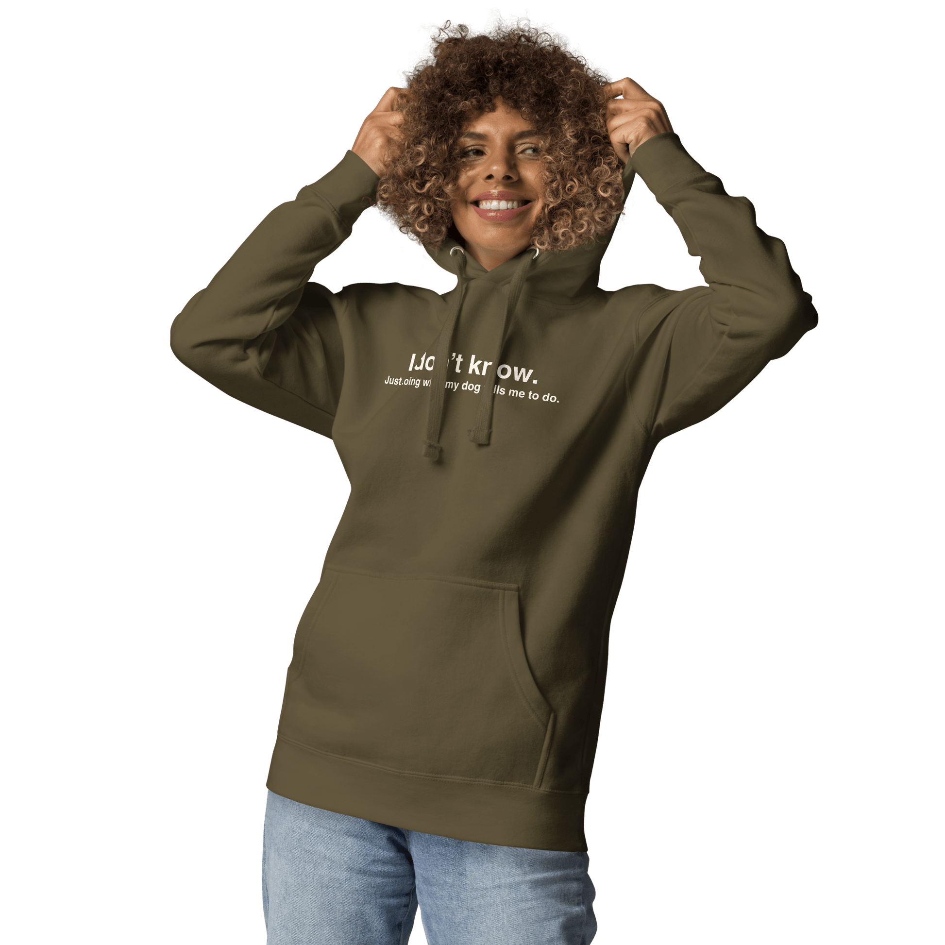 Smiling person adjusting the hood of a THiNK LiKE A DOG® Funny Dog Hoodie – Just Doing What My Dog Tells Me, in olive green, standing against a plain background—the perfect gift for any dog lover.