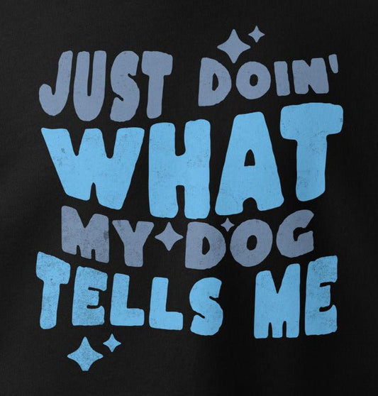 The "Just Doing What My Dog Tells Me" Hoodie by THiNK LiKE A DOG® features playful text and decorative stars on a black background, making this quirky, must-have apparel perfect for any dog lover's collection.
