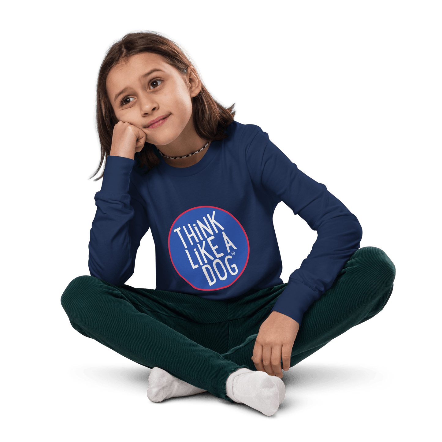 A child sits cross-legged, looking thoughtful in a blue "Kids' Think Like A Dog NASA-Style Long Sleeve Tee," featuring a fun and quirky design, by THiNK LiKE A DOG®.