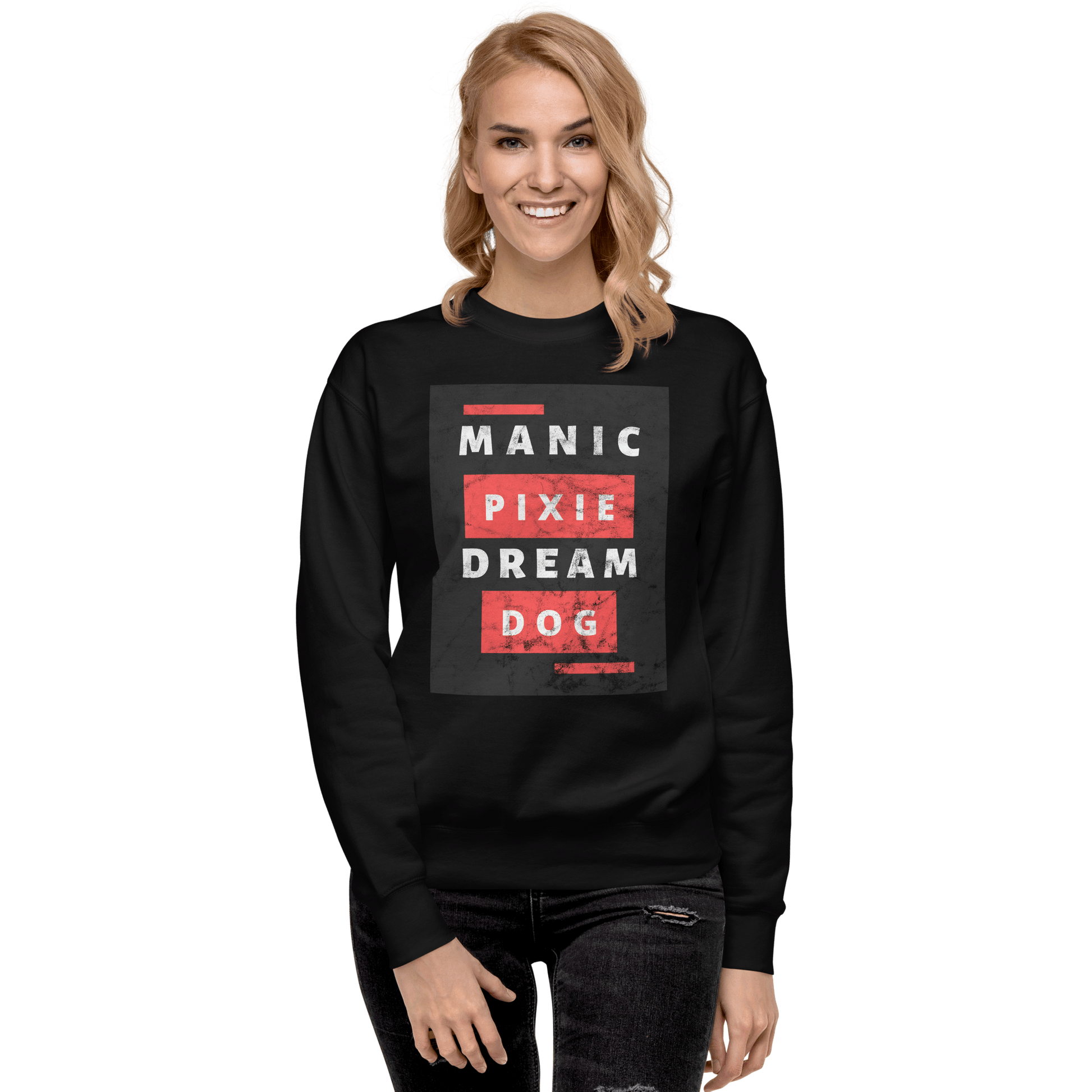 A woman with wavy blonde hair wears the THiNK LiKE A DOG® Manic Pixie Dream Dog Sweatshirt—Unique Funny Comfort—in black, featuring "Manic Pixie Dream Dog" in bold white and red, against a green background; ideal for dog lovers.
