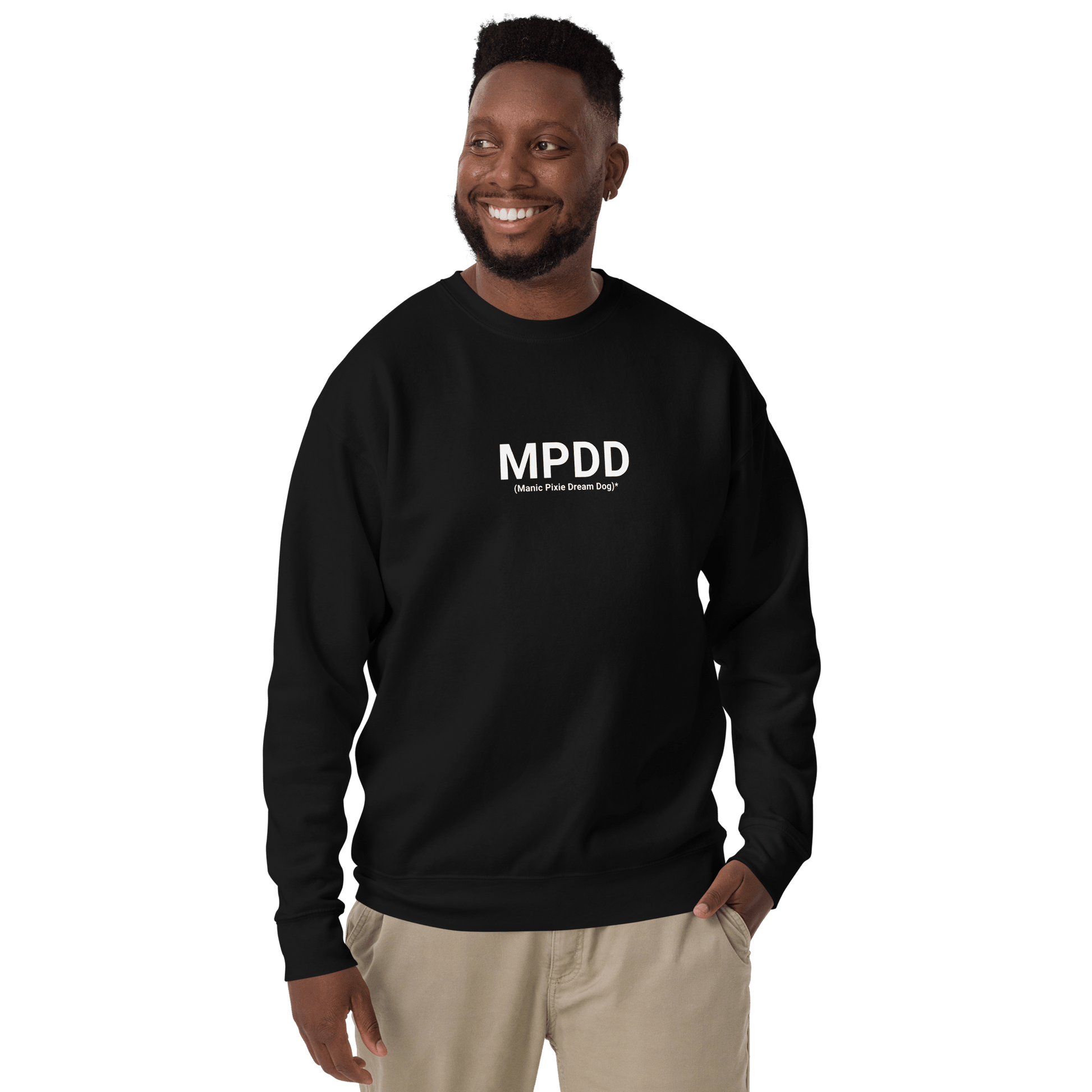 A man smiles, wearing a black Manic Pixie Dream Dog Definition Sweatshirt – Minimalist Comfort by THiNK LiKE A DOG®, featuring “MPDD (Means: Pick Drill Drop)” in white—a perfect gift for pet lovers.