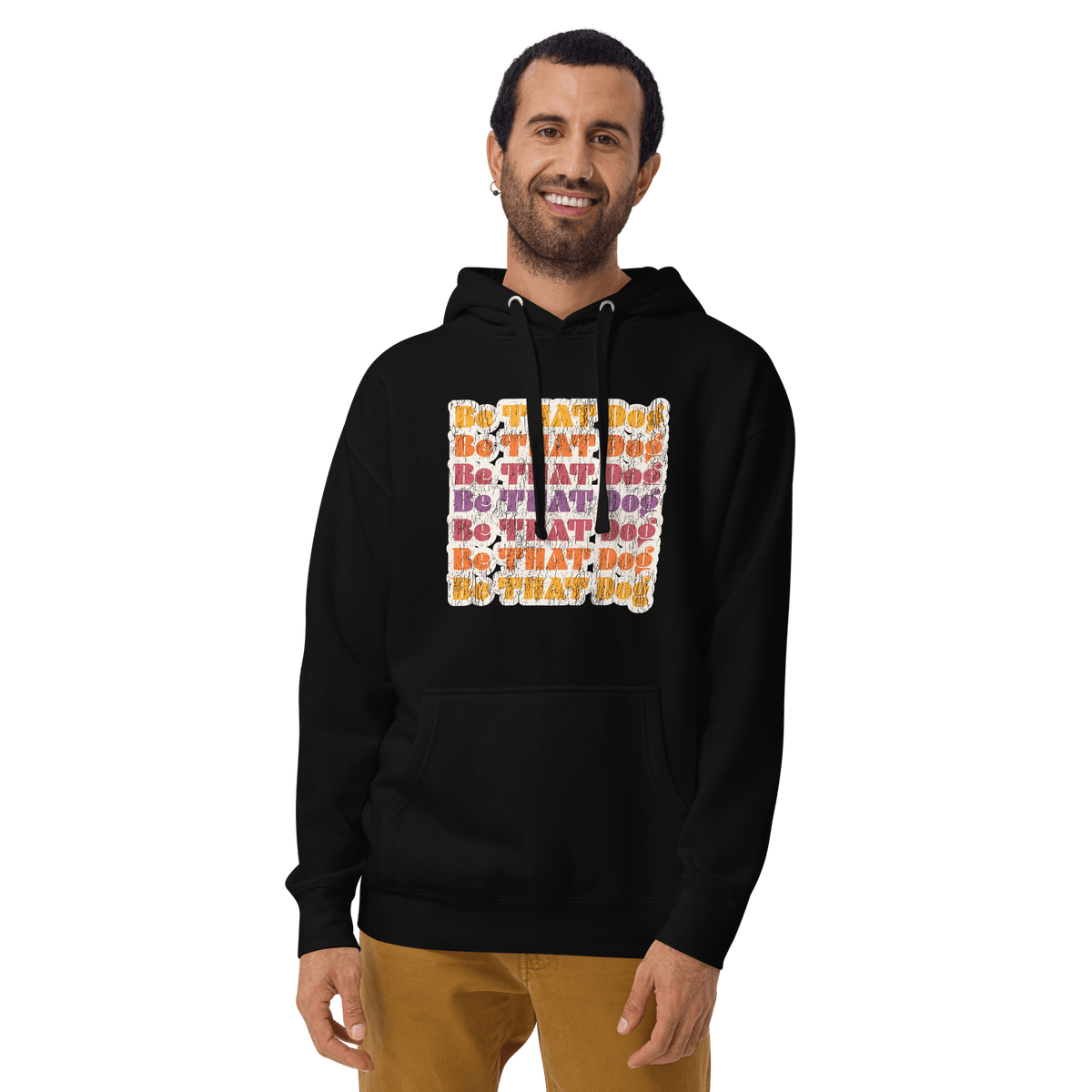 A man wears the THiNK LiKE A DOG® Be That Dog Hoodie – Retro Design, a cozy cotton fleece with colorful "DO THAT DOG"…
