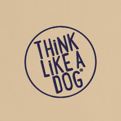 The THiNK LiKE A DOG® Eco-Friendly Beige Tote Bag features the phrase "Think Like a Dog" embroidered in a blue circular outline, crafted from durable materials.
