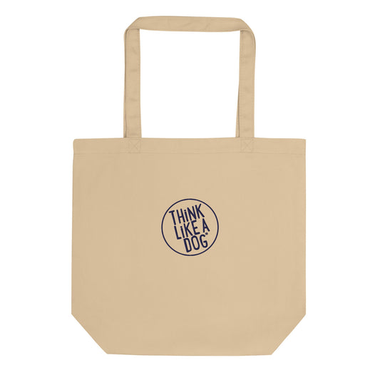 The THiNK LiKE A DOG® Eco-Friendly Beige Tote Bag, featuring long handles and crafted from durable materials, boasts an embroidered logo in the center that reads "THINK LIKE A DOG.