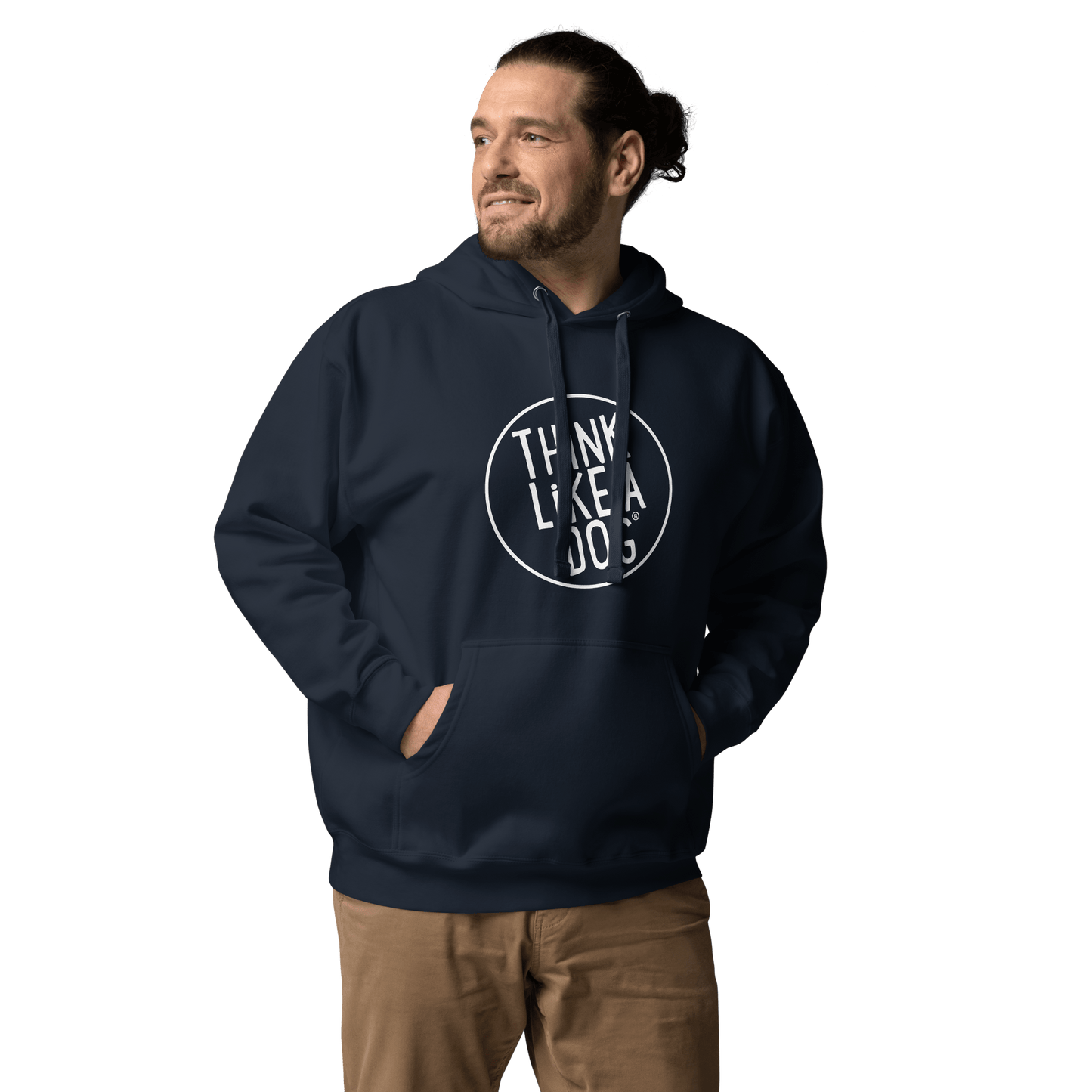 A man in a navy THiNK LiKE A DOG® Premium Hoodie, an ideal gift for dog lovers, has his hands in pockets, smiling and gazing to the side against a plain background.