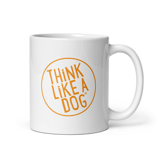 The THiNK LiKE A DOG®–Think Like A Dog Mug features a white ceramic design with a vibrant orange circular logo and “THINK LIKE A DOG” in capitals—an ideal gift for dog lovers.