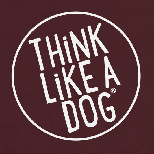 A maroon background with white text inside a white circle reads "THiNK LiKE A DOG®," making it perfect for the Kids' Cozy Crewneck Sweatshirt with White Think Like A Dog Logo from the brand THiNK LiKE A DOG®.