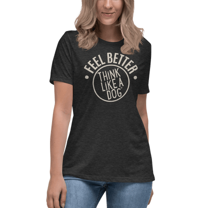 A woman in a THiNK LiKE A DOG® Feel Better Women's T-Shirt, emblazoned with "Feel Better, Think Like a Dog," pairs it effortlessly with blue jeans. This ultra-soft black tee is the perfect must-have for dog moms and animal enthusiasts.