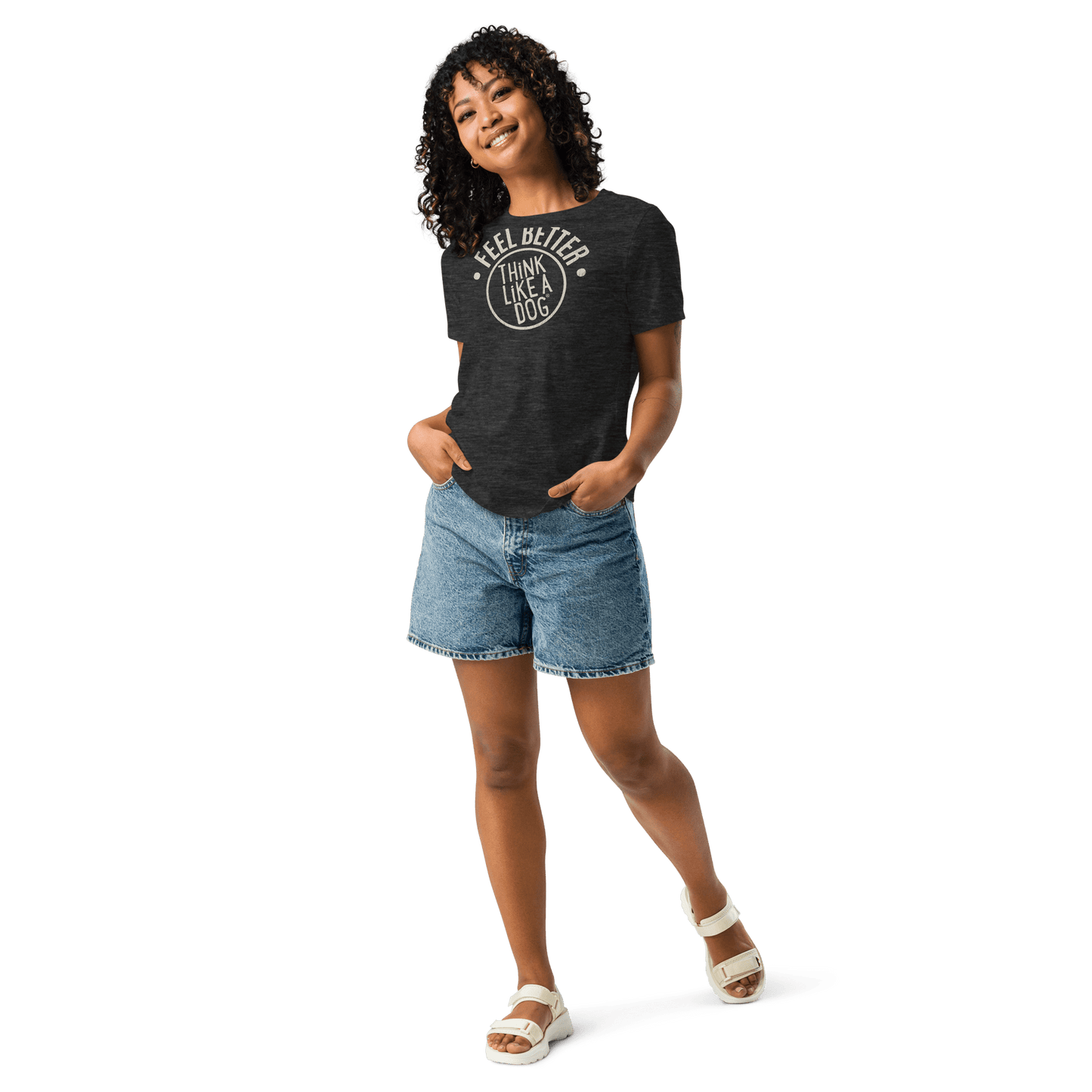 Smiling with hands in pockets, the person sports jean shorts, white sandals, and a THiNK LiKE A DOG® Feel Better Women's T-Shirt—an ultra-soft black top with "I Feel Better After I Lick A Dog," perfect for dog moms and animal enthusiasts.