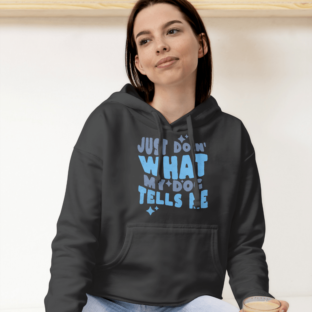 A casual person wears a THiNK LiKE A DOG® hoodie that says "Just Doing What My Dog Tells Me," making it a perfect gift for passionate dog lovers.