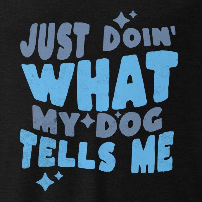 THiNK LiKE A DOG® presents the Quirky Dog-Themed Long Sleeve Shirt - 'Just Doin' What My Dog Tells Me', a black t-shirt adorned with playful blue and gray lettering and small star-like shapes. This funny dog shirt perfectly captures the spirit of anyone who lovingly obeys their four-legged friend.