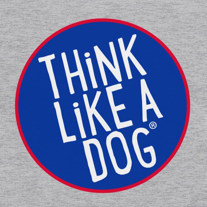 A cute and quirky design on a grey background features a blue circle with a red border and white text that reads "THiNK LiKE A DOG®". This graphic is showcased on the Kids' Think Like A Dog NASA-Style Long Sleeve Tee - Cute and Quirky Dog Apparel, making it an ideal choice for any dog lover. The tee is crafted from high-quality soft fabric, ensuring comfort for your little ones.
