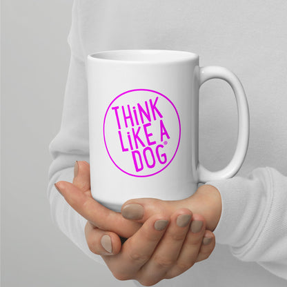A person holding a White Glossy Mug Magenta THiNK LiKE A DOG® Logo with the phrase "THiNK LiKE A DOG®" inside a pink circle.