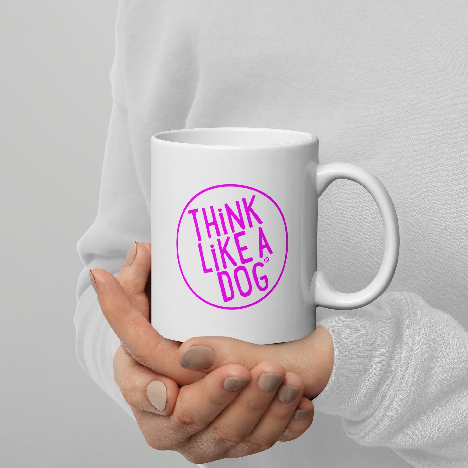 Person holding a White Glossy Mug Magenta THiNK LiKE A DOG® Logo with "THiNK LiKE A DOG®" printed on it.