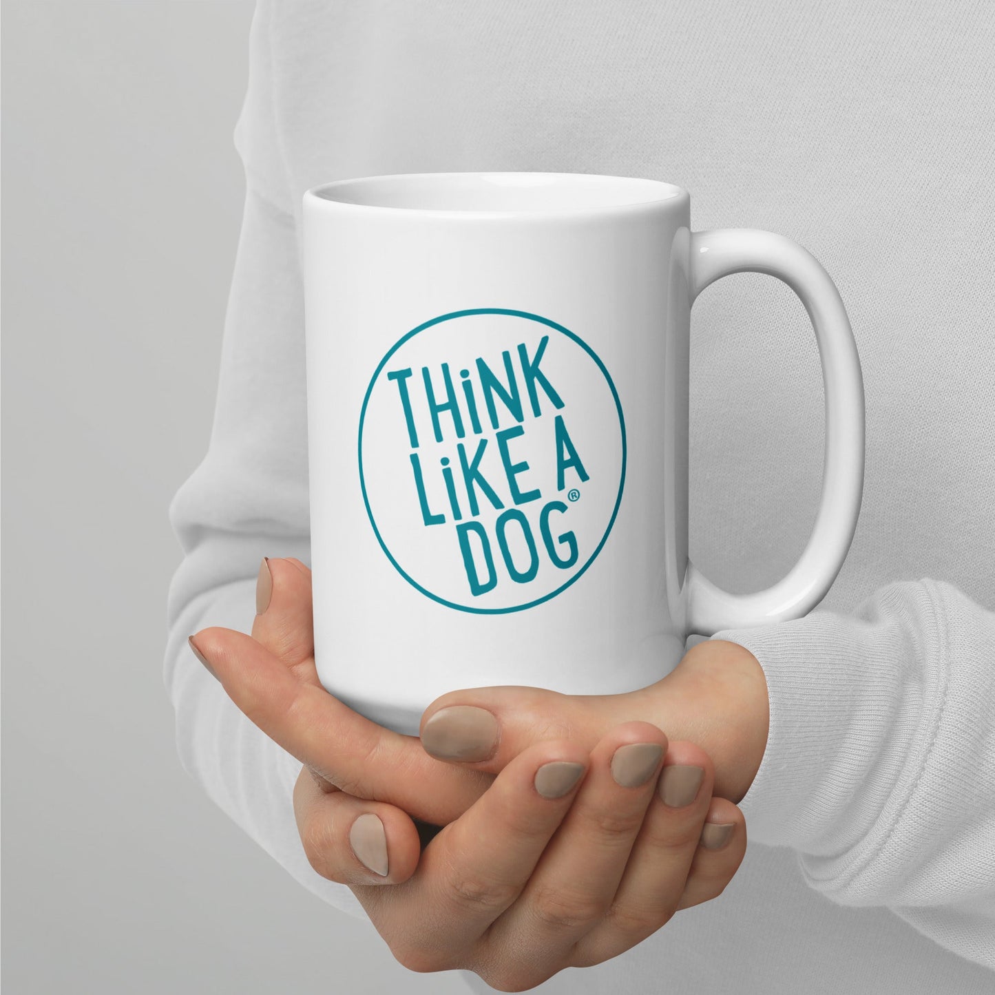 Person holding a White Glossy Mug Teal THiNK LiKE A DOG® Logo with the phrase "THiNK LiKE A DOG®" printed on it.